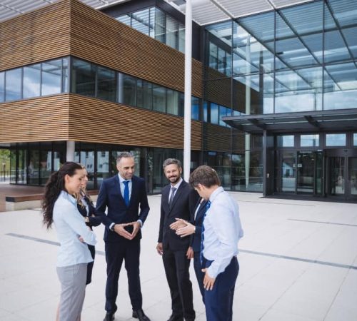 group-businesspeople-interacting-outside-office-building